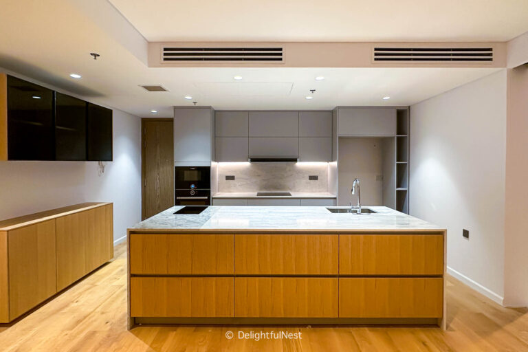 a kitchen with a large waterfall island that has a seam in the center.